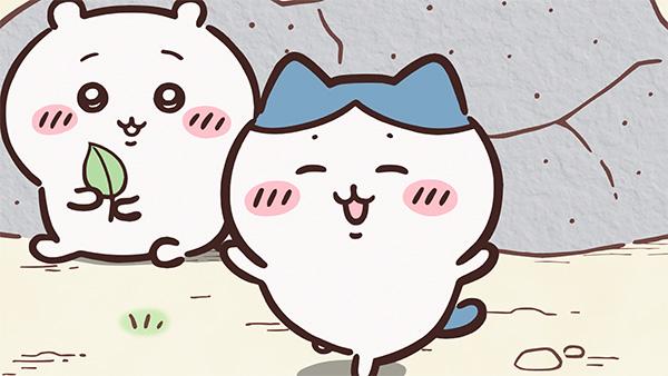 岩の前で目を細めて笑うハチワレと、その後ろで葉っぱを持って座るちいかわ。アニメ「ちいかわ」第160話「ほめられリボン①」の場面