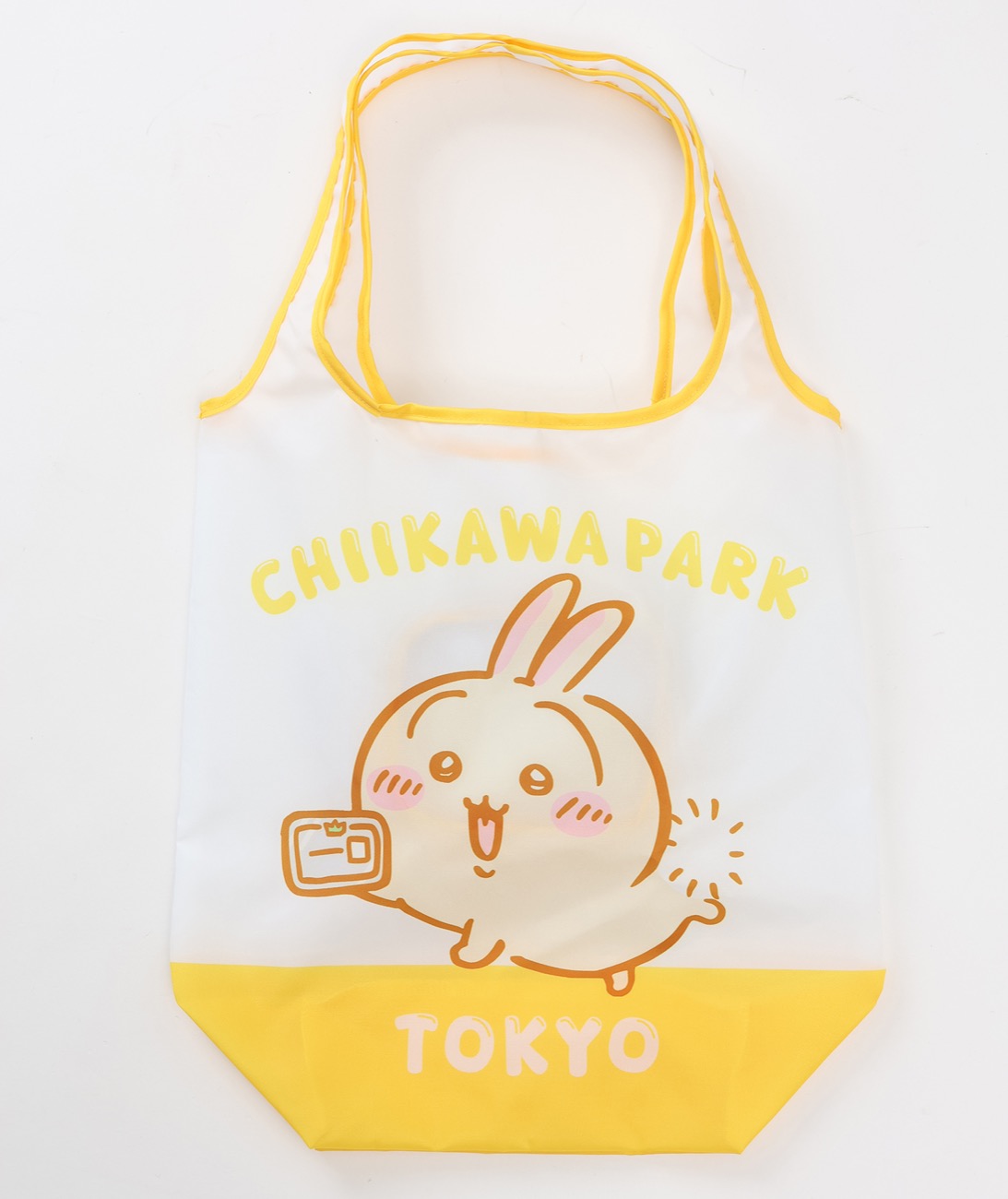 ちいかわパーク エコバッグ 草むしり検定2級 イエローの公式画像。CHIIKAWA PARK TOKYO の文字と、合格証を持ってほほえむうさぎが描かれた、黄色い持ち手と底の白いエコバッグ