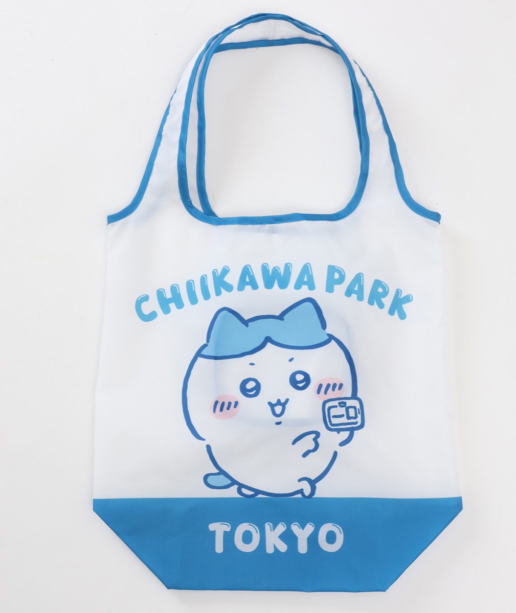 ちいかわパーク エコバッグ 草むしり検定5級（ハチワレ）ブルーの公式画像。CHIIKAWA PARK と TOKYO の文字と、検定証を手に持ったハチワレが描かれた、青い持ち手と底の白いエコバッグ