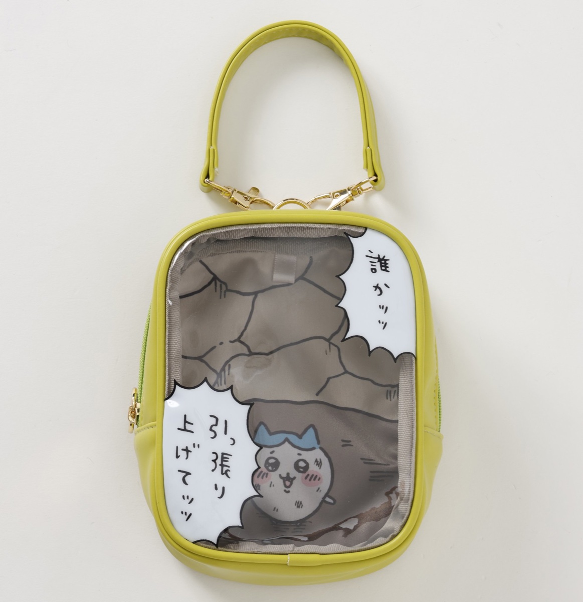 ちいかわパーク おでかけポーチ 穴に落ちたハチワレ グリーンの公式画像。穴の底のハチワレと吹き出しが描かれた、黄緑の持ち手つきの透明窓ポーチ