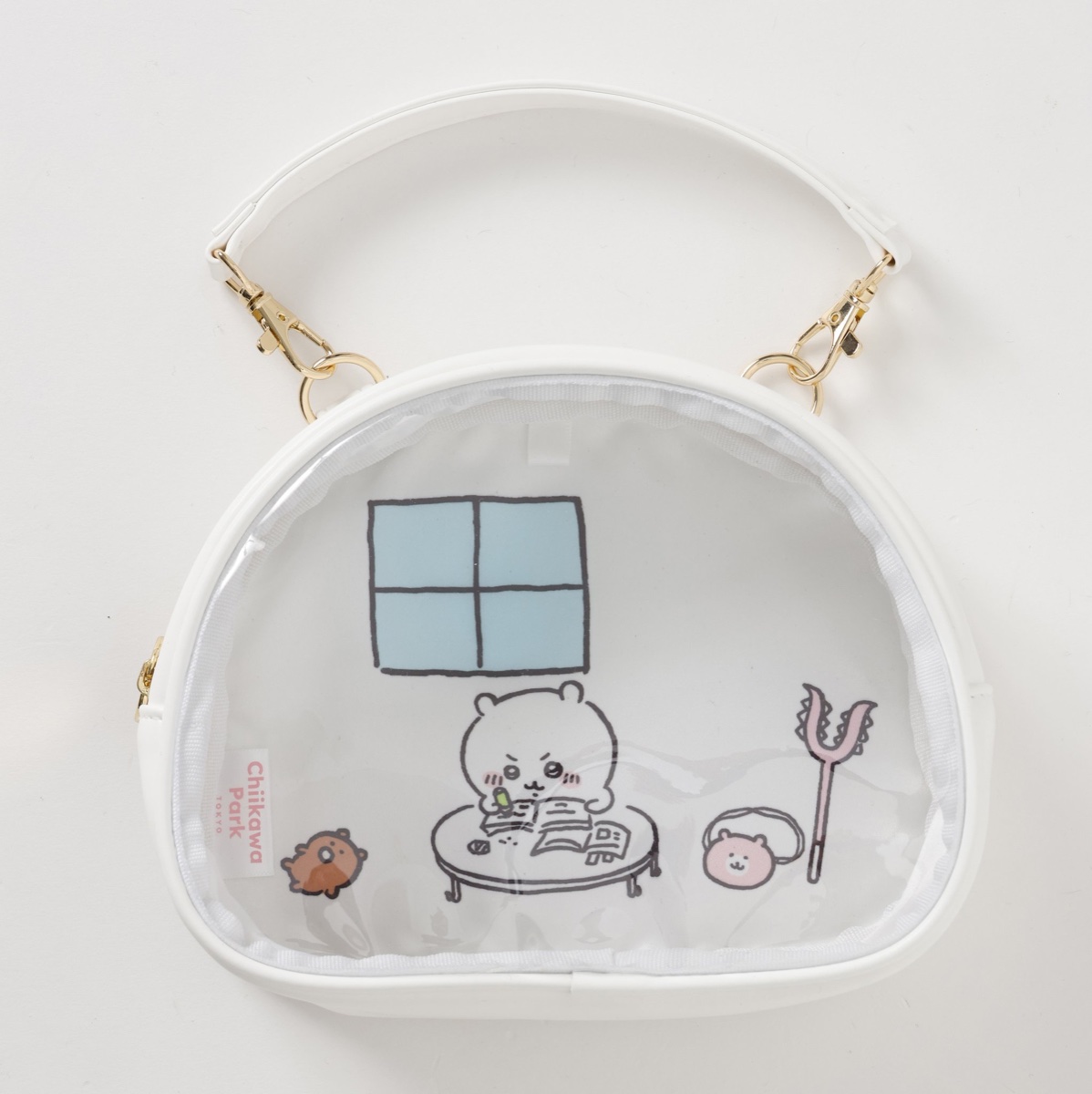 ちいかわパーク おでかけポーチ ちいかわの家 ホワイトの公式画像。窓のある部屋で机に向かうちいかわが描かれた、持ち手つきの透明窓ポーチ